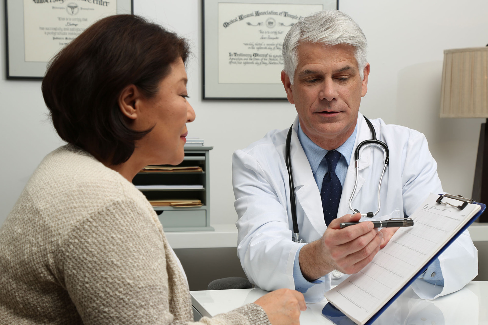 Doctor and Patient in Conversation Looking at EKG Print Out