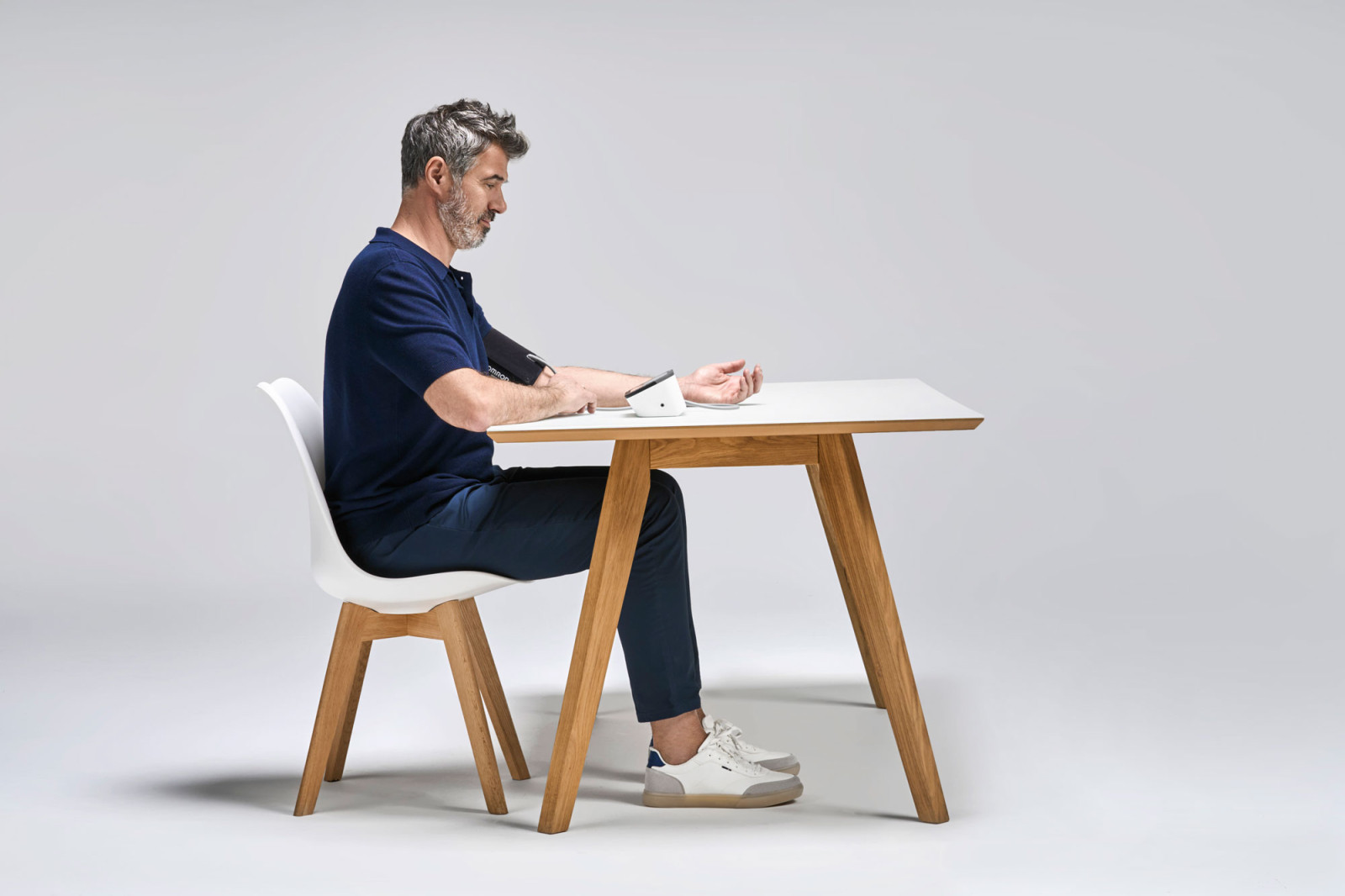 Man taking blood pressure from side at desk