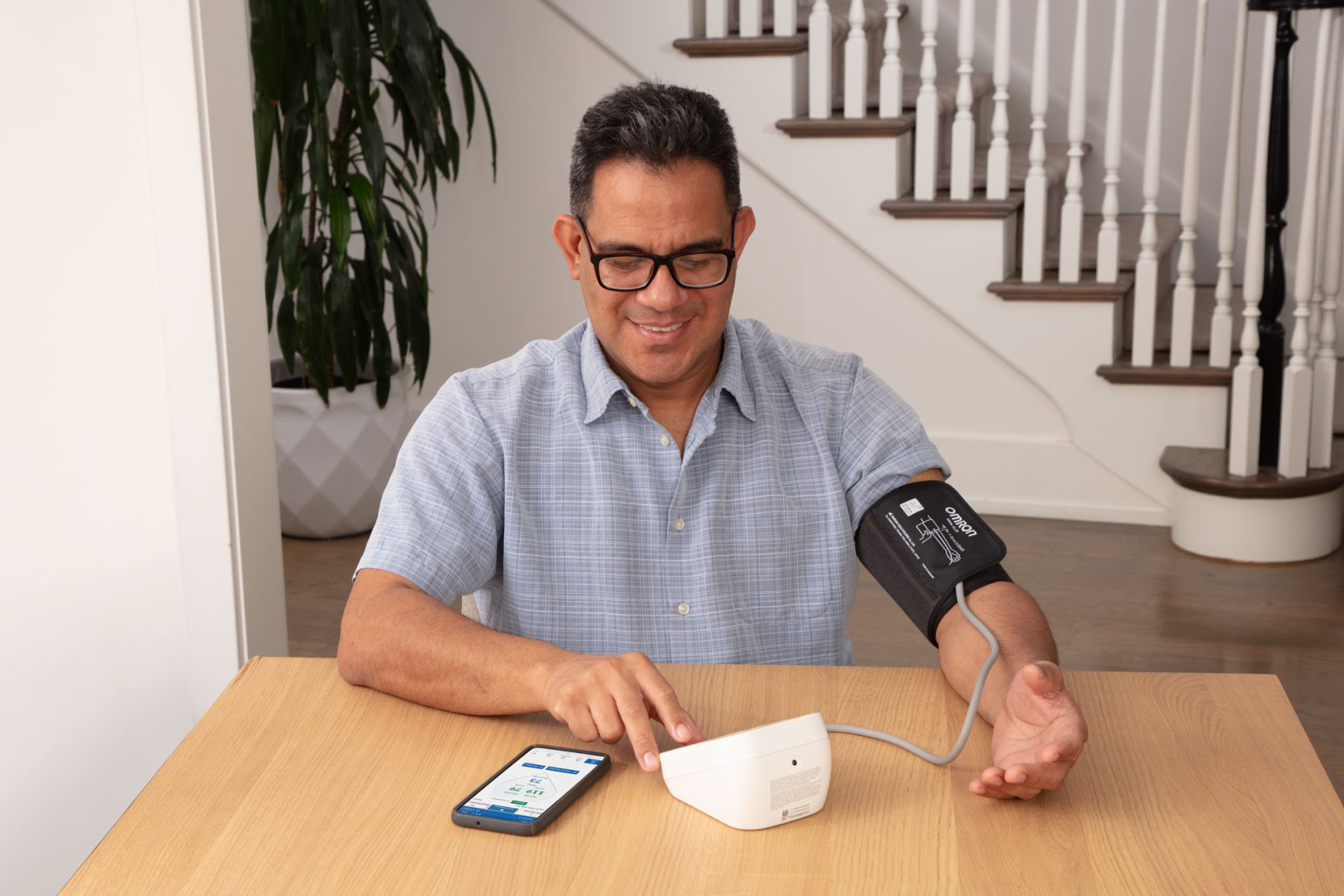 Man taking blood pressure monitor at home