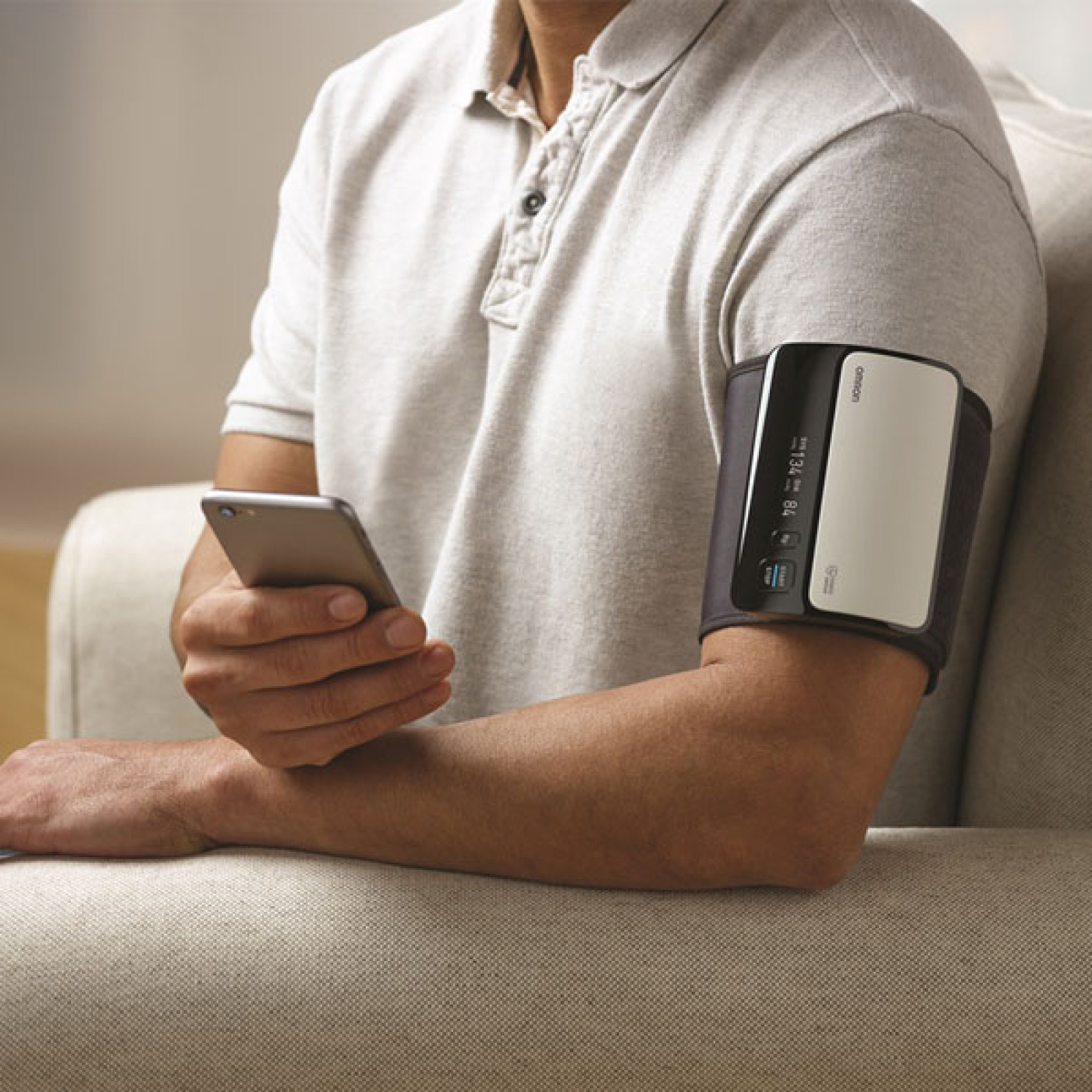 Man taking blood pressure monitor at home