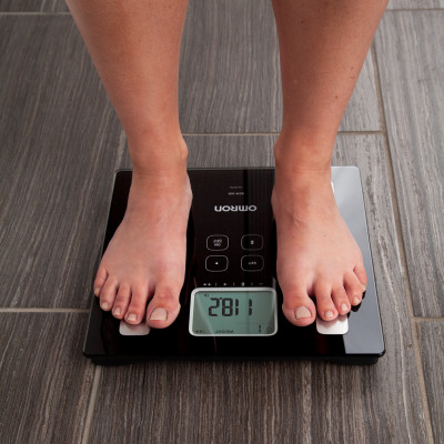 Woman standing on body composition monitor and scale