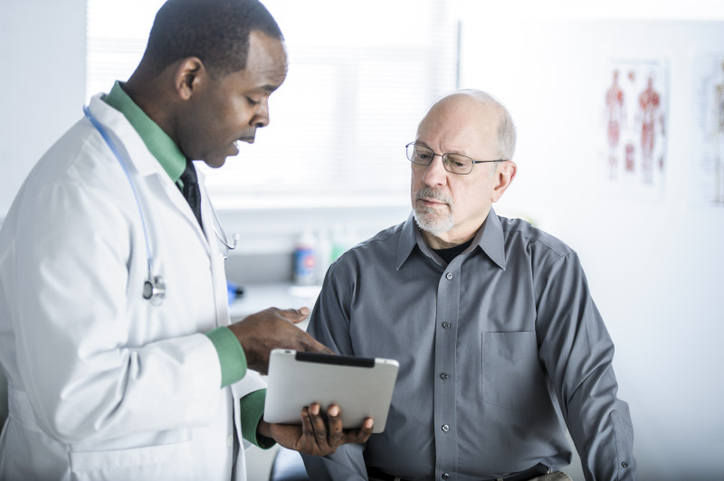 African American Doctor Talking to Patient in Office