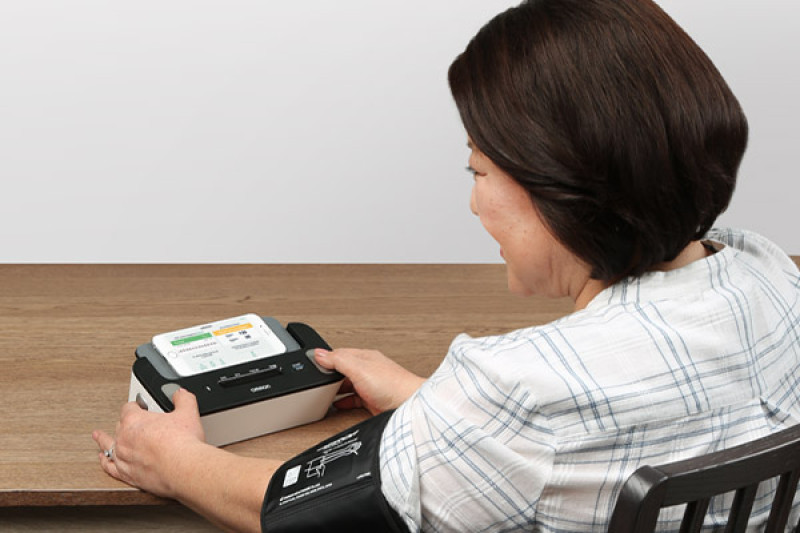 Complete Upper Arm Blood Pressure Monitor & EKG - Lifestyle: Woman taking bp reading | OMRON