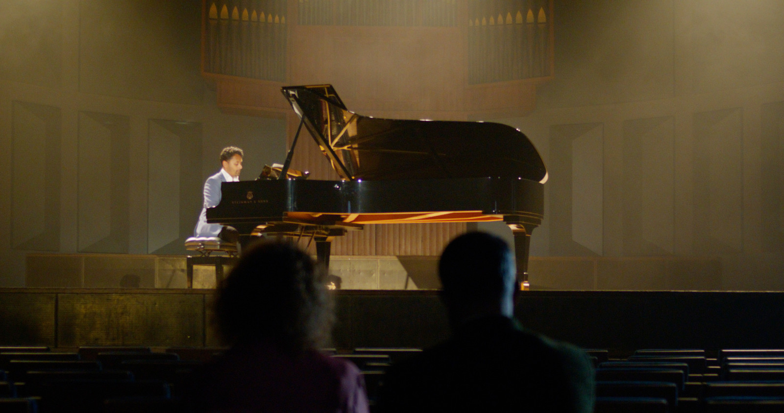 Man playing piano in auditorium